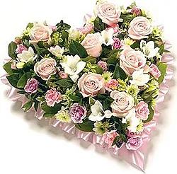 Corazón fúnebre de rosas pastel, claveles y flores mixtas