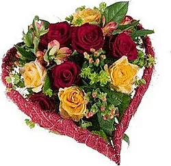 Corazón fúnebre de rosas y flores mixtas en colores cálidos