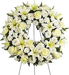Corona funeraria de delicadas rosas, lirios, crisantemos y flores mixtas