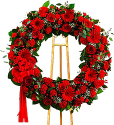 Corona funeraria de rosas rojas, gerberas, claveles y flores mixtas